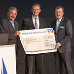 Jürgen Topp (links) und Thomas Rühl (rechts) überreichen einen symbolischen Scheck über 4.000 Euro an Klaus Arnold, den Vorsitzenden der Bürgerstiftung Mittelhessen (Mitte).